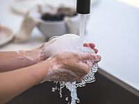 Washing hands with soap under a water tap